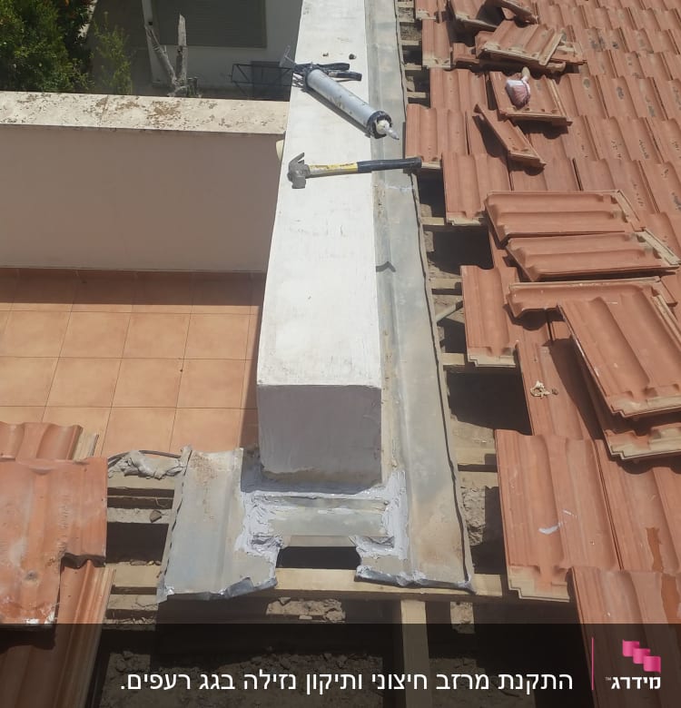 גג עם רעפים שבורים וכלי עבודה